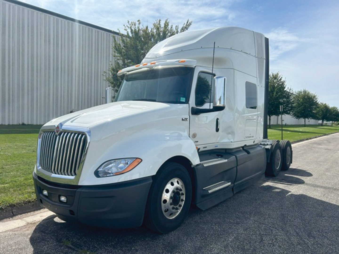International LT625 tractor unit with sleeper cab, white exterior, showing front grille and side view