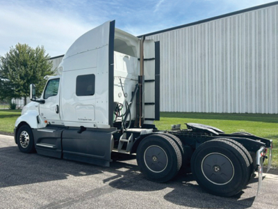 Truck cab and chassis of a 2023 International LT625 with sleeper cab, side view showing rear dual axles and fifth wheel area.