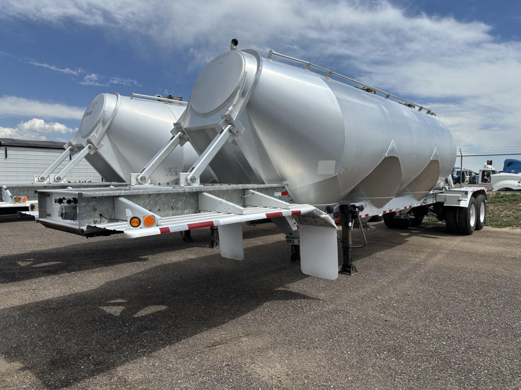 Polar Gravity Drop Pneumatic trailer showing dual cylindrical tanks on a tandem axle with silver paint and rear loading ramps.