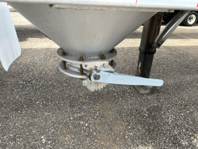 Pneumatic trailer component showing a gravity drop with a clamped discharge valve and lever in view.