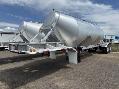 Polar Gravity Drop Pneumatic trailer showing dual cylindrical tanks on a tandem axle with silver paint and rear loading ramps.