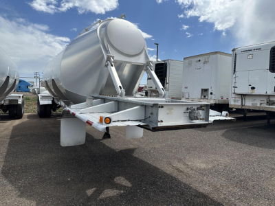 Trailer rear/side view of a 2012 Polar gravity drop pneumatic trailer showing a cylindrical tank and undercarriage with support frame and landing gear.
