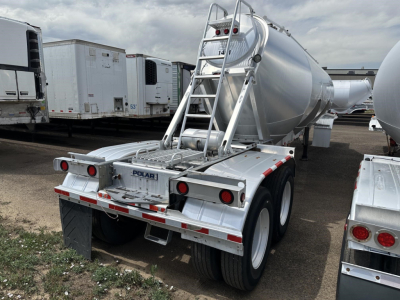 Pneumatic trailer in a lot, rear view showing Polar branding, dual rear axles, galvanized metal tank, ladder, and safety rails.