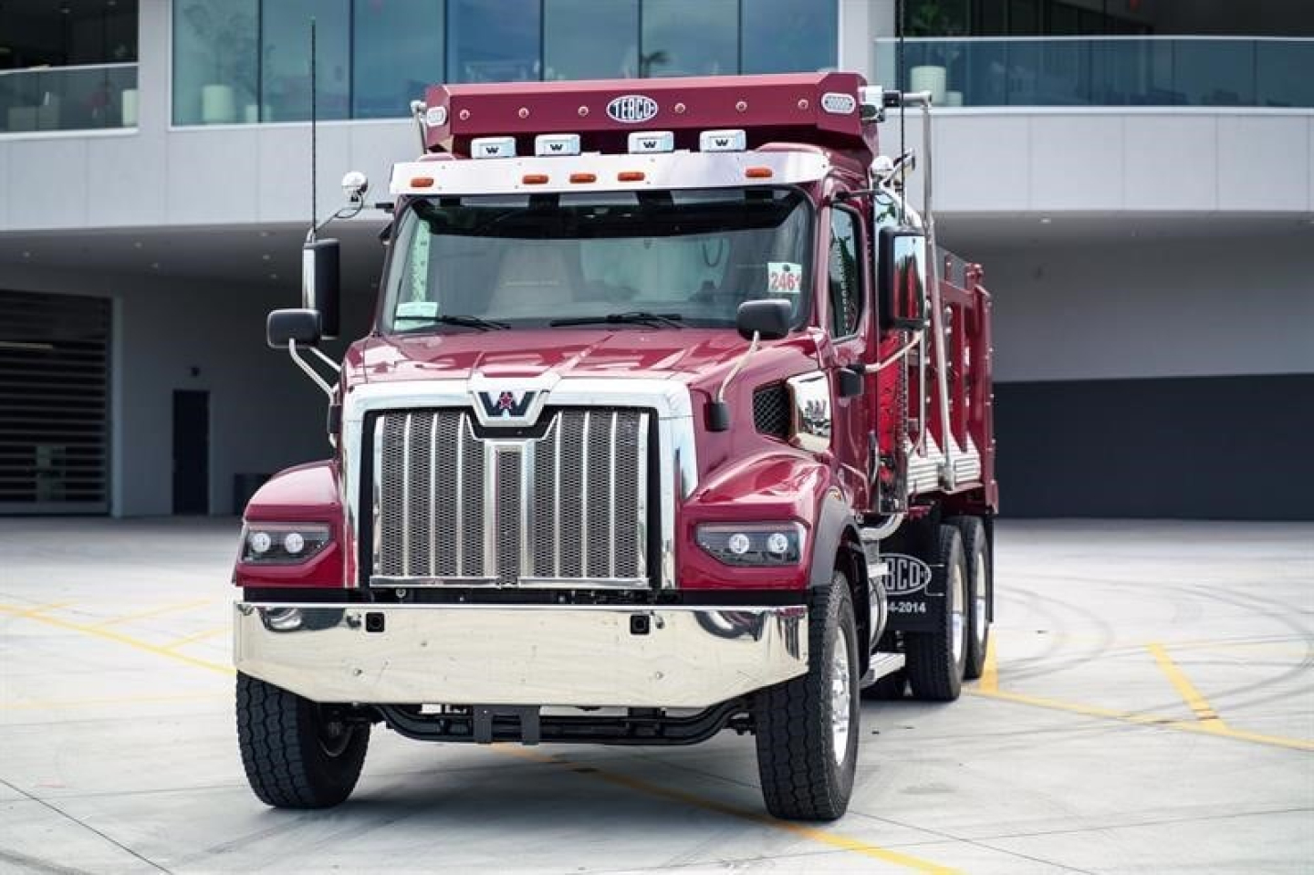 Western Star 47X dump truck front view showing bold chrome grille, maroon paint, and large bumper.