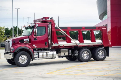 Western Star 47X dump truck in maroon showing side view with dump bed and chrome exhaust stack.