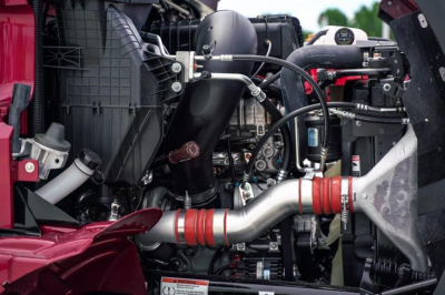 Engine bay of a Western Star 47X dump truck showing intake pipe, hoses, and components.