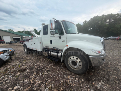 White International 4300 tow truck side view showing dual rear wheels and service body with steps; cab badge reads 4300.