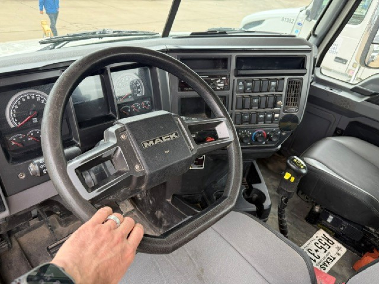 Interior of a Mack GR64FT truck cab showing steering wheel with Mack logo and dashboard controls.