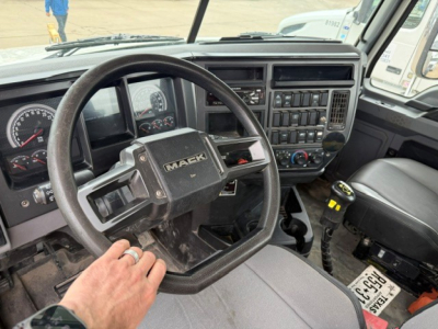 Interior of a Mack GR64FT truck cab showing steering wheel with Mack logo and dashboard controls.