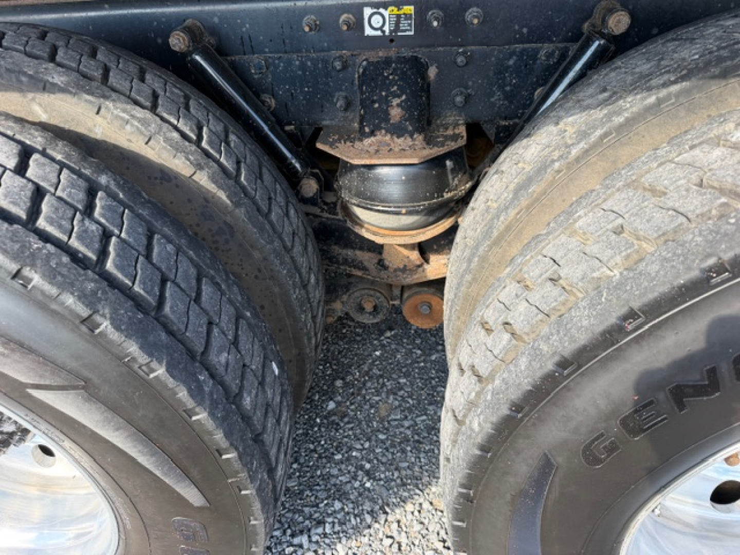 Kenworth T880 undercarriage showing rear dual wheels and drive axle housing with suspension components.