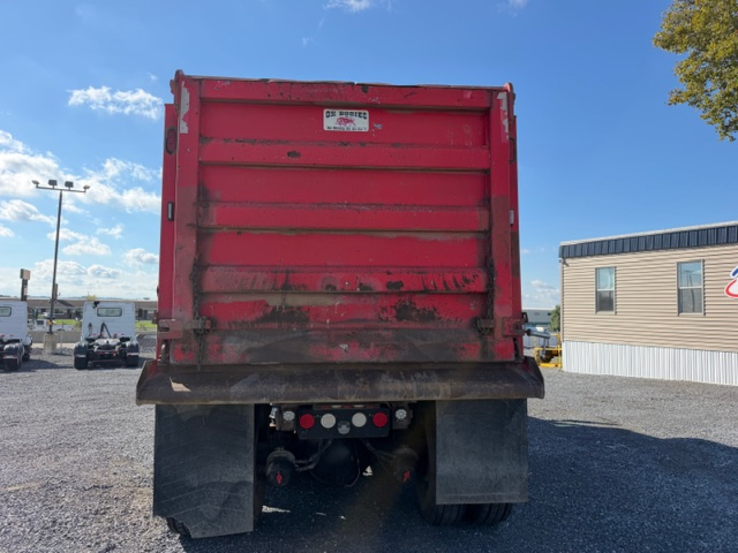 Dump truck bed of a 2017 Kenworth T880 showing red dump body and rear bumper with taillights and undercarriage components.