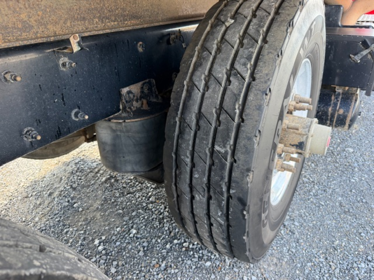Kenworth T880 wheel and front suspension view showing dual tires and chassis components.