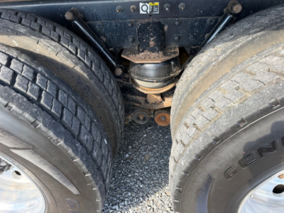 Kenworth T880 undercarriage showing rear dual wheels and drive axle housing with suspension components.