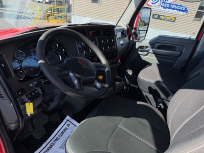 Kenworth T880 interior cab view showing steering wheel, dashboard gauges, gear shifter, and driver seat in aUsed truck listing.