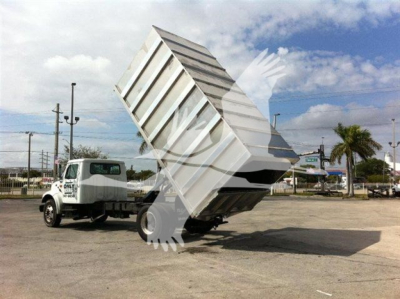 Dump truck with raised dumping bed in a dealership lot showing Advanced Fabricators Ft equipment.