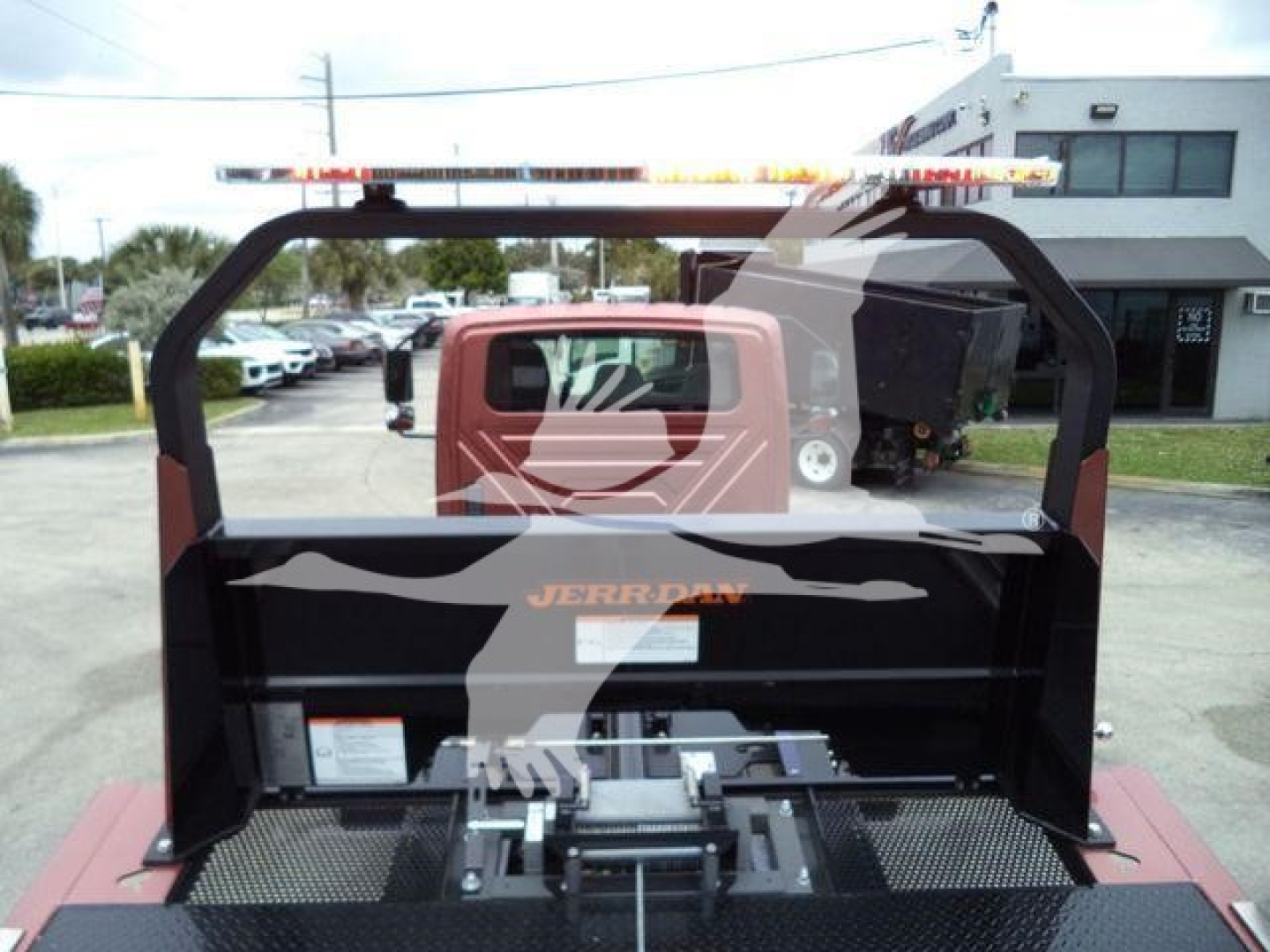 Truck bed with rollback equipment and mounting frame visible; EVAP and hydraulic components with hoses and controls.