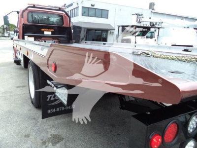 Truck bed of a 2020 International MV rollback showing flatbed with metal diamond plate and rear wheels visible.