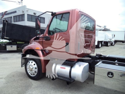 Truck cab side view of a red 2020 International MV rollback truck showing fuel tank and chassis.