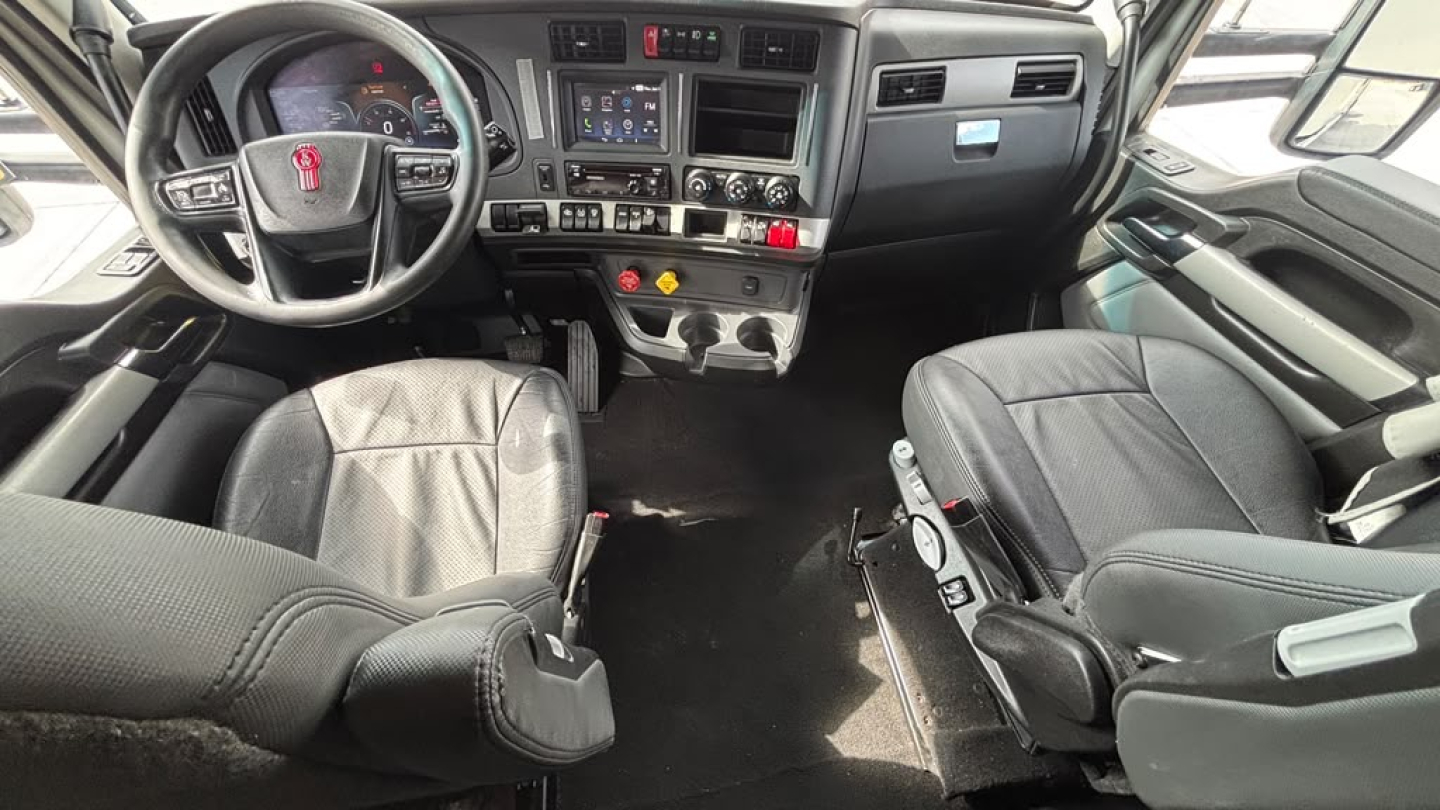 Kenworth T680 truck interior view showing steering wheel, dashboard, and two captain seats