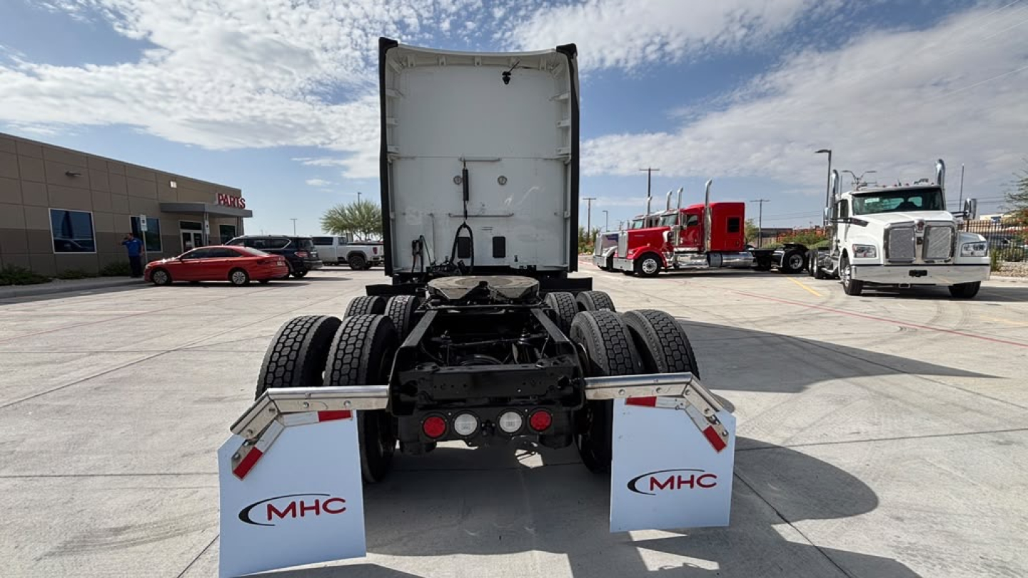 Kenworth T680 tractor rear view showing dual rear wheels and fifth wheel, with mud flaps labeled MHC.