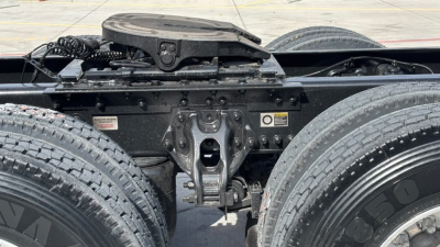 Kenworth T680 chassis and fifth wheel area with dual rear axle and visible hitch, front view showing frame and suspension components.