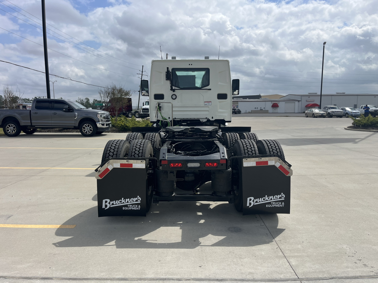 Truck rear view showing fifth-wheel area and dual rear axles with mud flaps and Bruckner’s trucks branding.