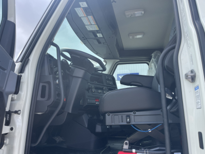 Mack AN64T cab interior showing steering wheel, driver seat, dashboard, and control panel from open door angle.