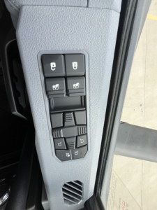 Panel of truck cab showing window control switches and mirror adjustments in a Mack AN64T interior