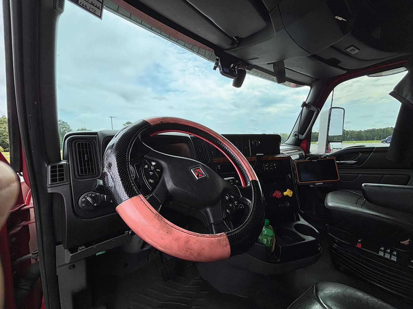 Interior of a 2020 International LT625 truck showing steering wheel, dashboard, and driver seat area.