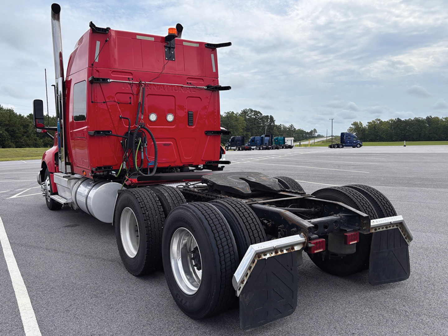 Rear view of a red 2020 International LT625 conventional sleeper truck showing dual rear axles, chassis, and mud flaps.