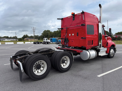 International LT625 truck cab tractor rear view showing rear triple axles and fuel tanks with exhaust stack