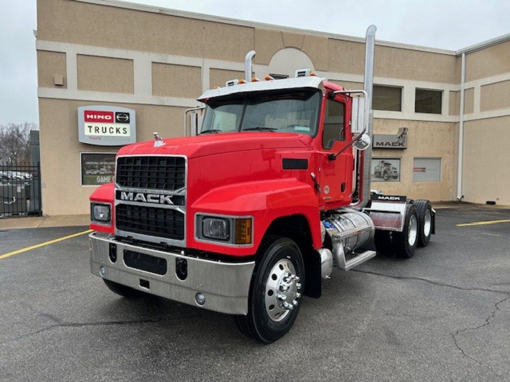 Mack PI64T conventional daycab truck in red, front and side view, showing chrome bumper, grille, dual exhaust stacks, large mirrors, and single rear axle configuration.