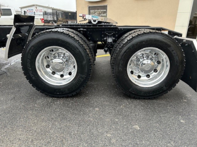 Dual rear axles of a 2026 Mack PI64T truck showing chrome wheels and tires with dual-tire configuration.