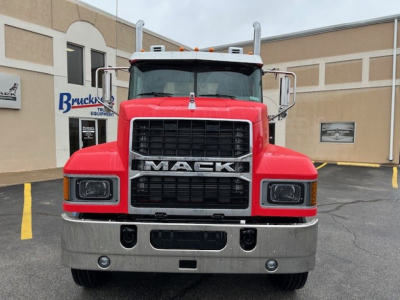 Front view of red 2026 Mack PI64T conventional daycab with large grille, black Mack emblem, chrome bumper, and dual mirrors.