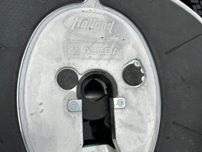 Wheel hub showing Holland ALCOA circular cover with keyhole area and hub cap for Mack PI64T truck wheel.