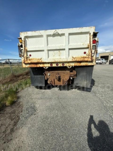 Dump truck bed of a 2006 International 5500i with rusted rear, empty tailgate, and rear hitch assembly visible.