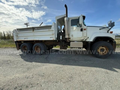 International 5500i dump truck side view showing white cab and dump bed with dual rear axles and heavy-duty tires.