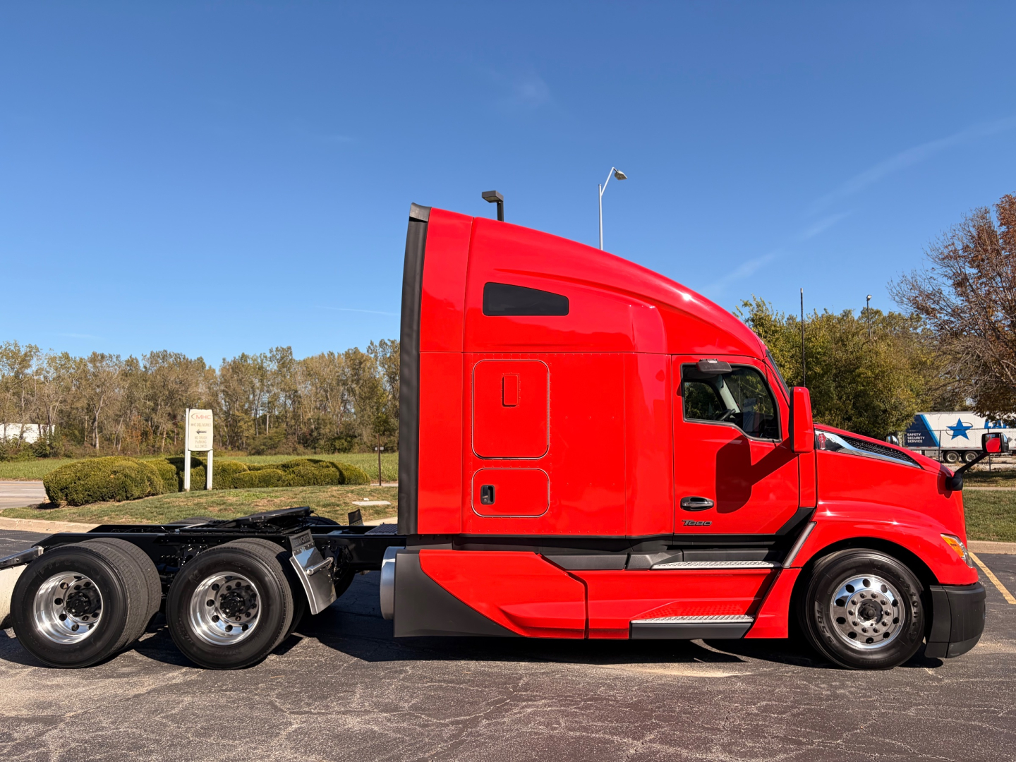 Kenworth T680 semi-truck in red, side view showing cab and chassis with multiple wheels, no visible text on decals.