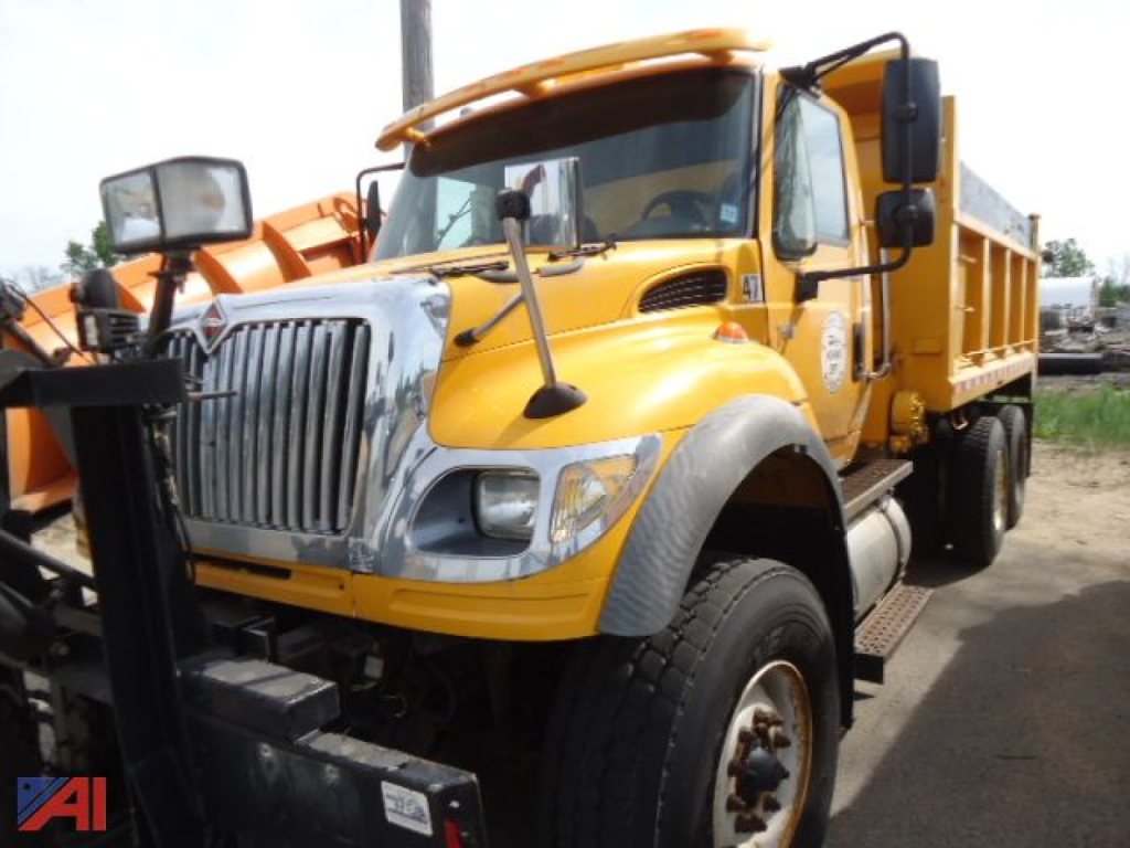 International WorkStar 7600 side dump truck with wing dump body showing yellow paint and black grille