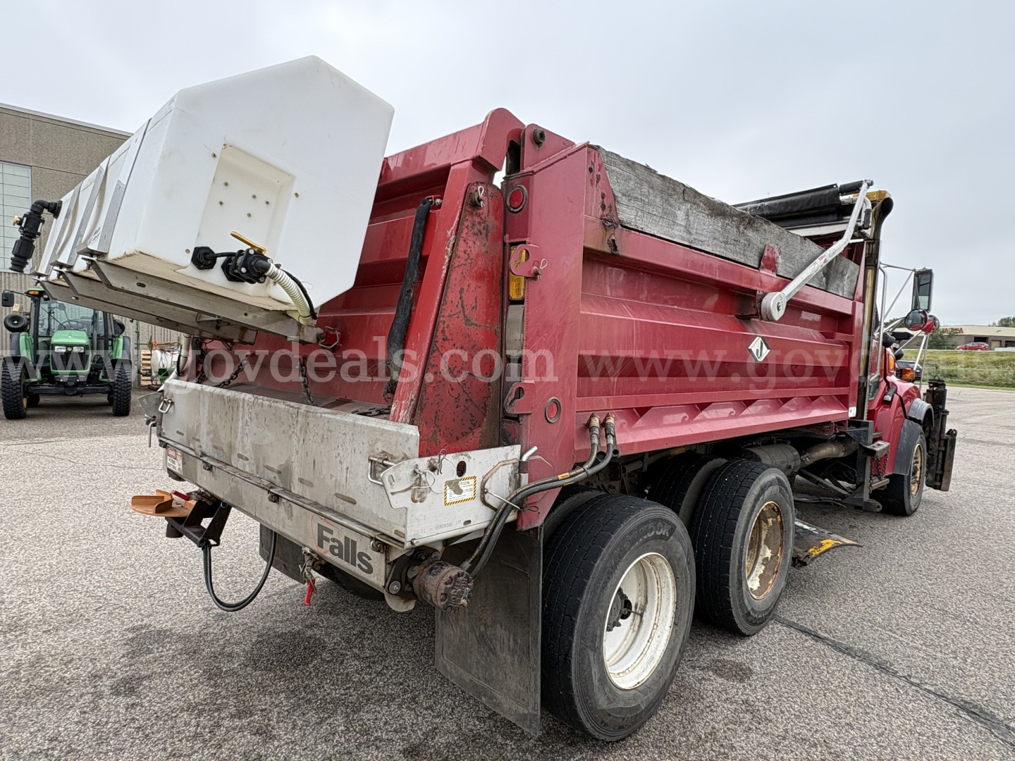 Sterling LT9500 series dump truck rear and side view showing red dump bed with white tailgate and hydraulic components; visible dual rear axles and tires.