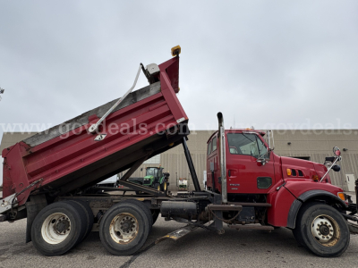 2001 Sterling LT9500 dump truck with red cab and dump bed raised, three-axle configuration, front grille and wheel details visible.