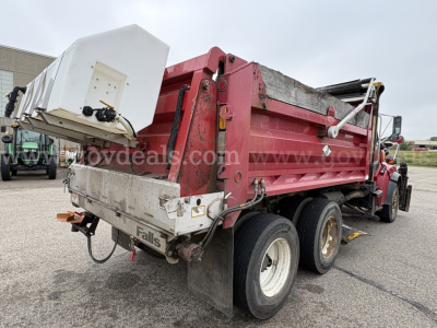 Sterling LT9500 series dump truck rear and side view showing red dump bed with white tailgate and hydraulic components; visible dual rear axles and tires.