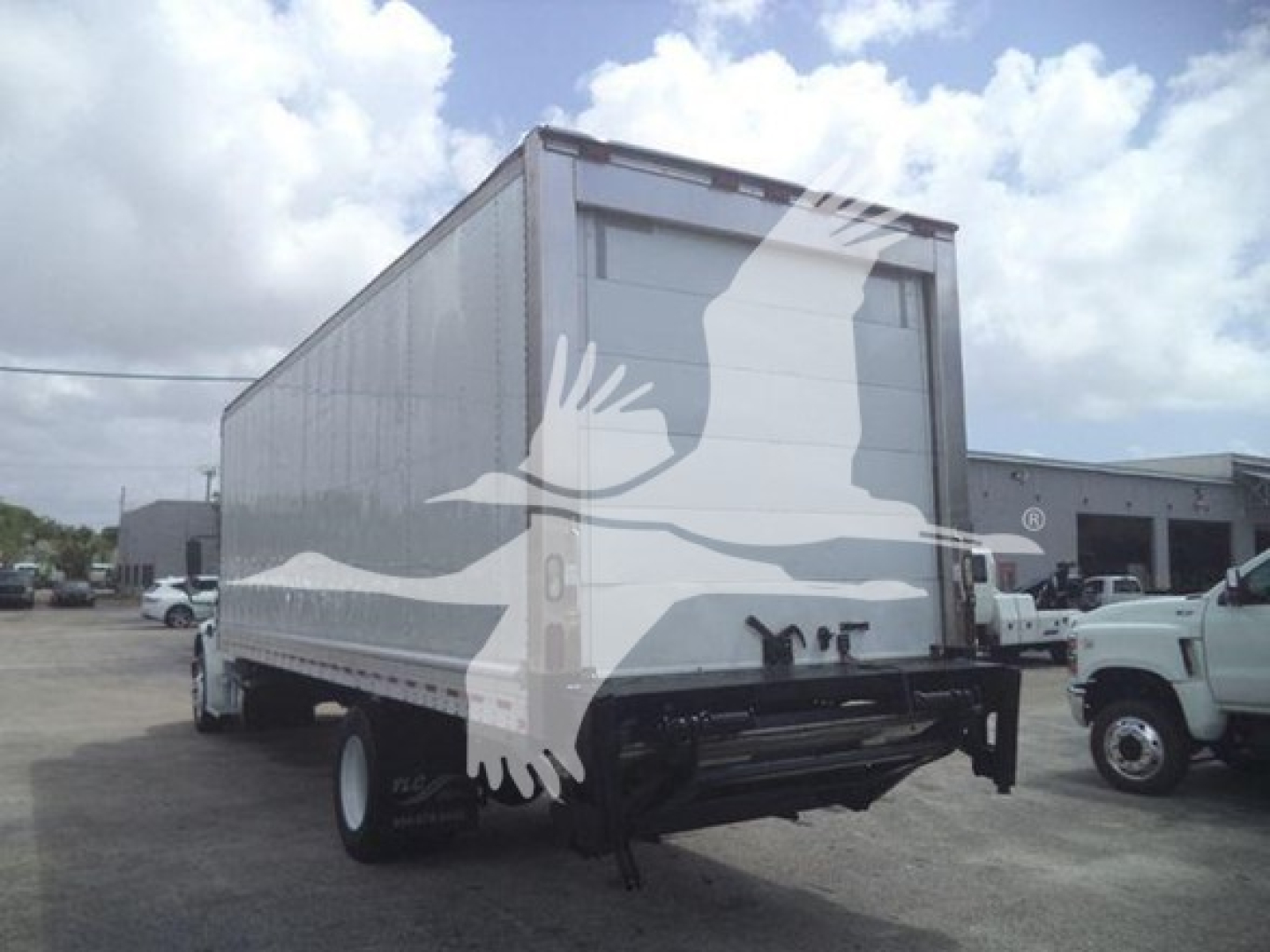 Freightliner M2 106 box truck rear view showing cargo trailer with white body and black bumper
