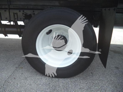 Wheel of Freightliner box truck showing white steel rim and black tire with trailer undercarriage visible