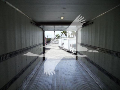 Truck trailer interior viewed from rear with open doors, showing empty cargo area and some light fixtures on ceiling.