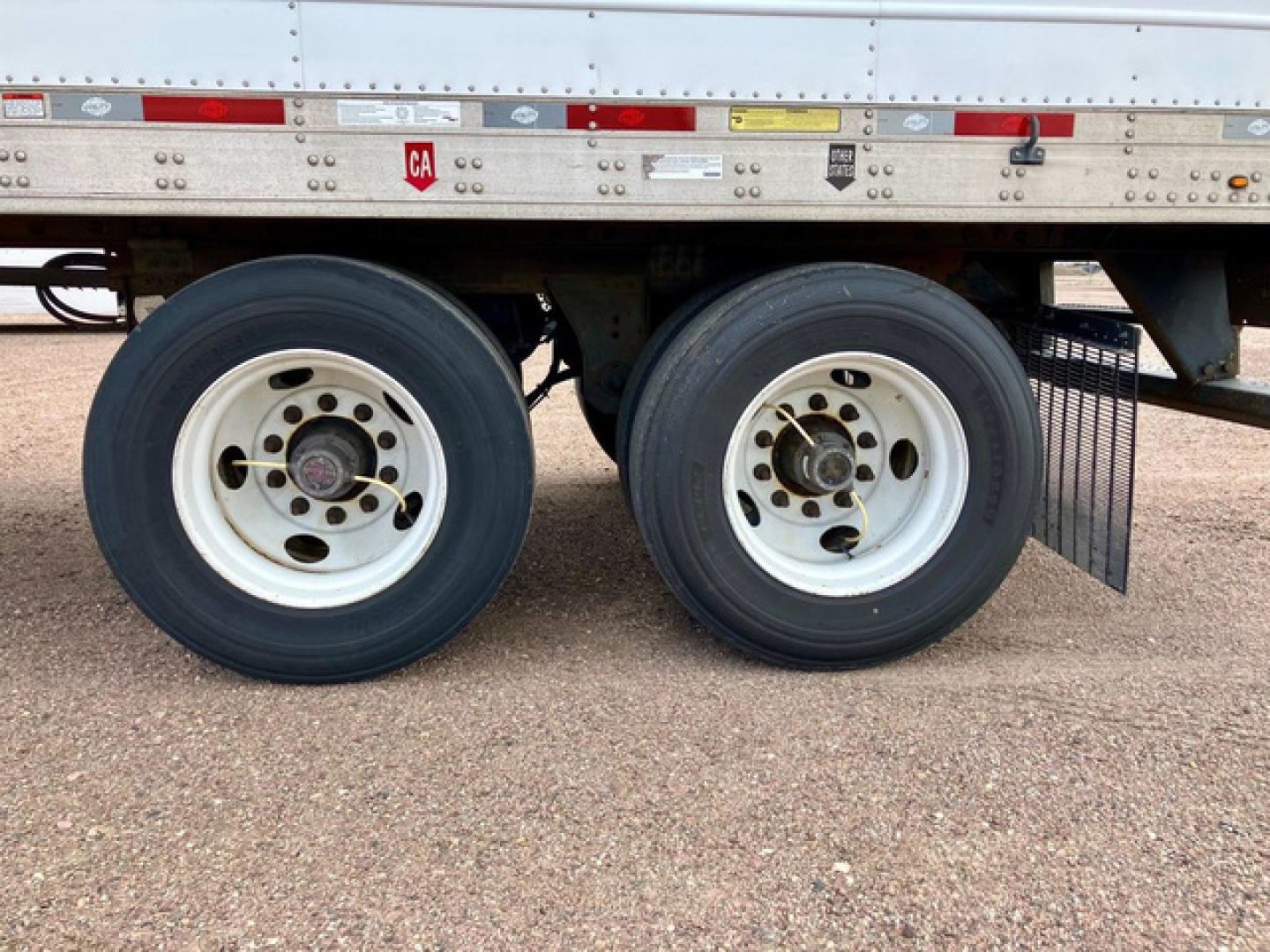 Dual rear trailer wheels of a 2022 Utility Reefer trailer showing tandem axles and tires with white rims.