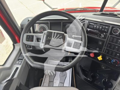 Mack Anthem 64T truck interior cab with steering wheel, dashboard, gauges, and gear shifter. Visible text includes 'MACK' on steering wheel center and various control labels on dashboard.