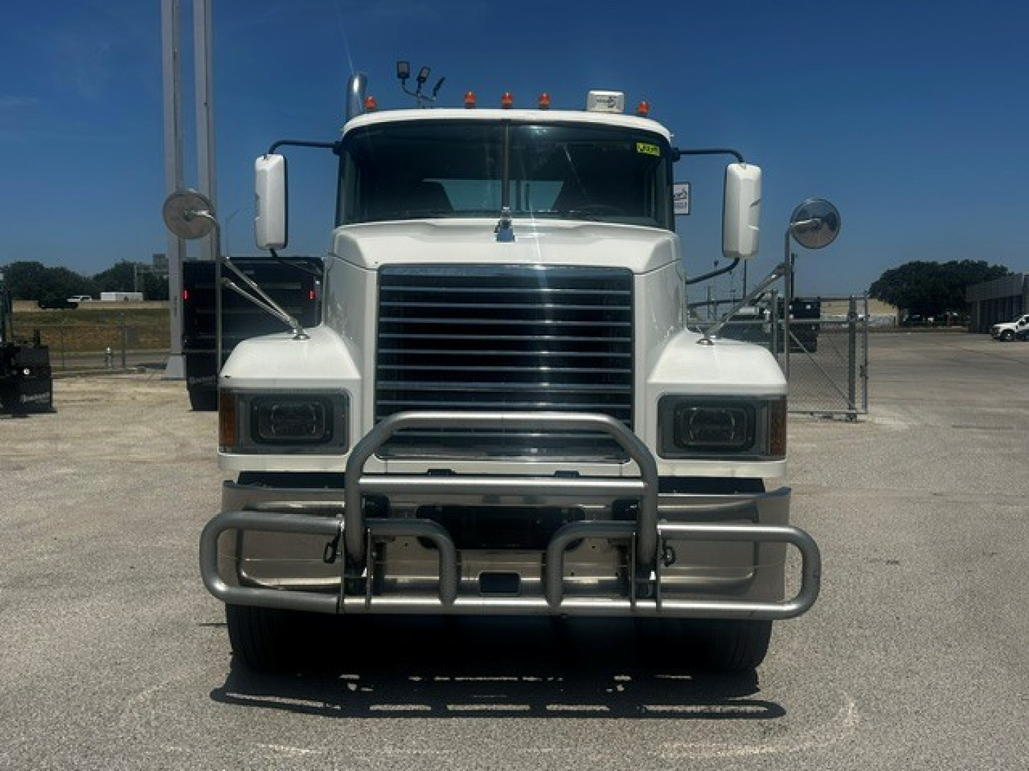 Front view of a white 2020 Mack PI64T conventional daycab truck with a heavy-duty bumper guard, grille, large side mirrors, and clearance lights.