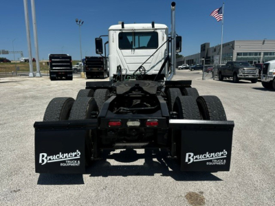 Mack PI64T truck chassis rear view showing dual fuel mud flaps with Bruckner's Truck & Equipment logo and fifth-wheel area.