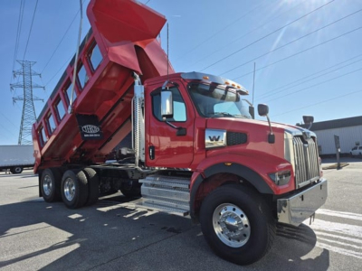 Western Star 47x dump truck in red, side view with dump bed raised.